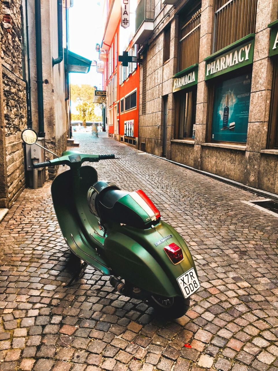 green motor scooter parked beside building